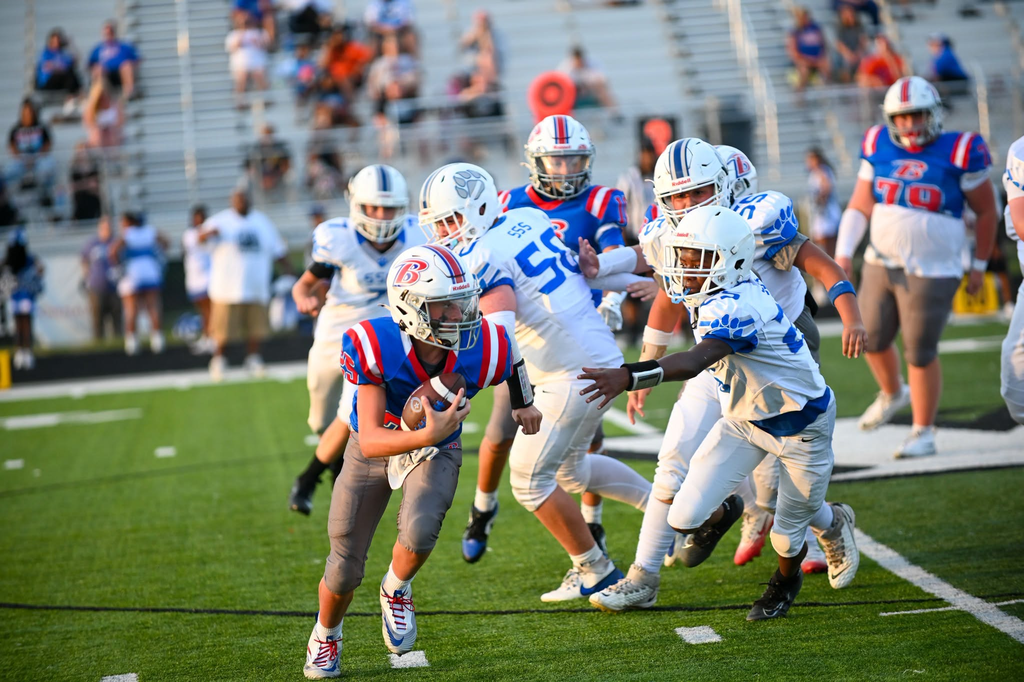 BMS football player runs with the football.