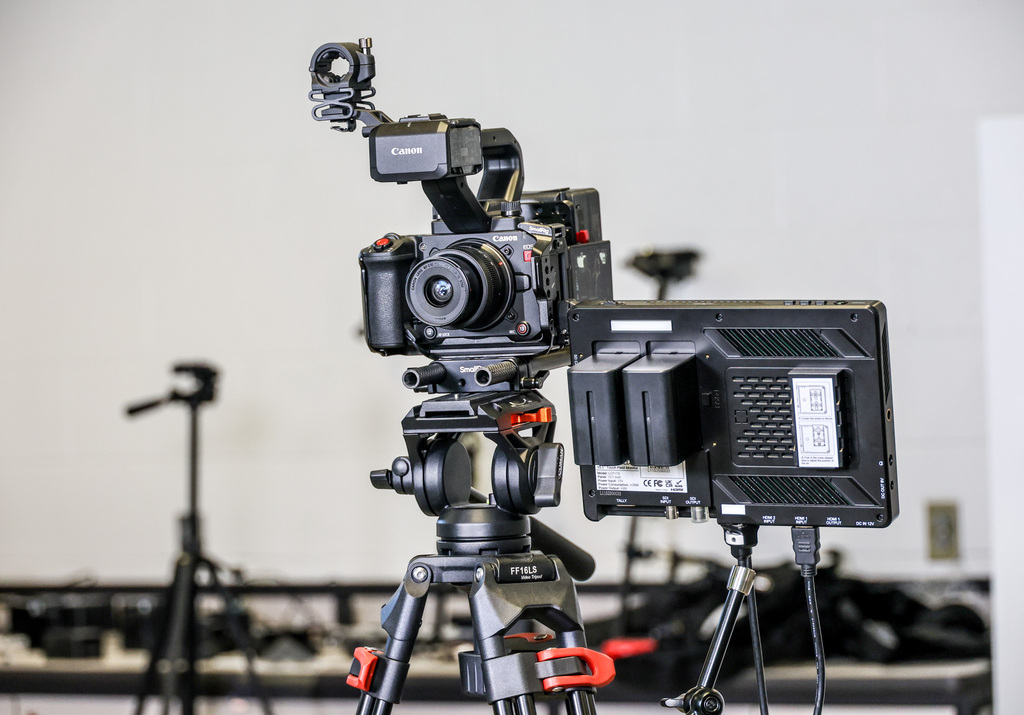 Media Arts program camera on a tripod with a light fixture next to it.