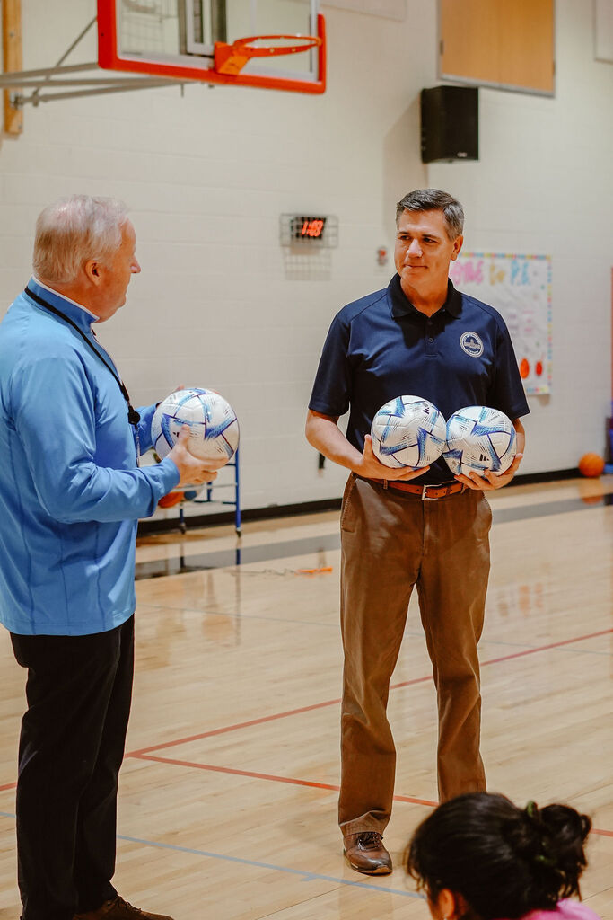 Fifa representative stands with Superintendent Mark Kopp as they speak to a group.