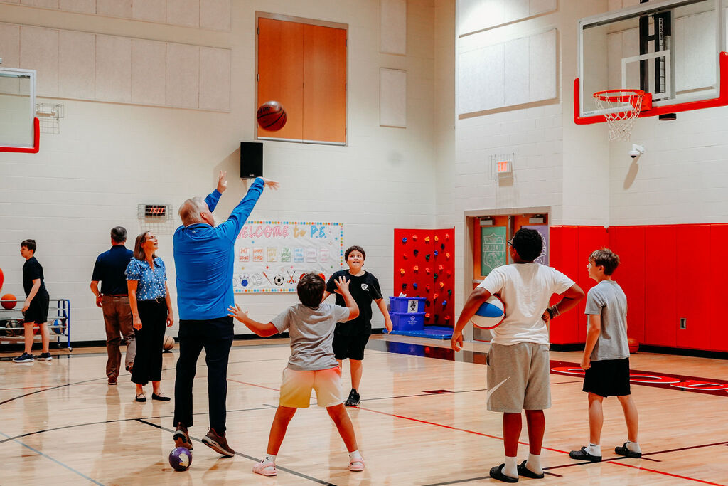 Superintendent Kopp shoots a basketball with students at Collins Lane Elementary.