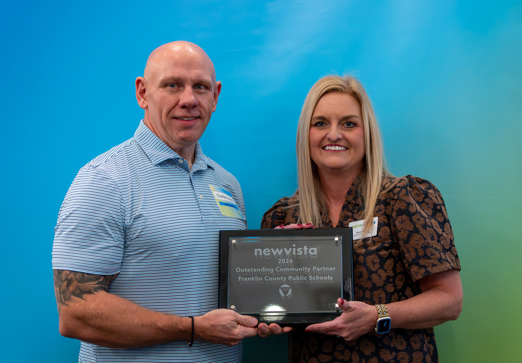 Charles Lewis, Director of College and Career Readiness, stands with the New Vista CEO holding the award.