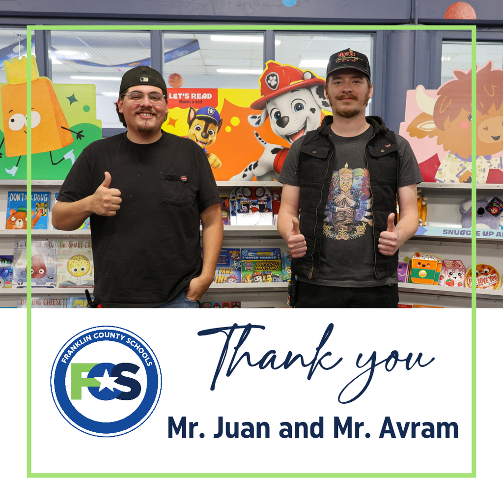 Mr. Juan and Mr. Avram stand side-by-side giving thumbs-up signs in front of colorful Scholastic book fair displays.