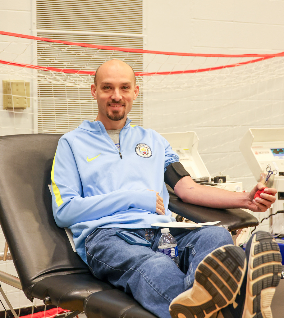 WHHS staff member smiles as he prepares to donate blood.