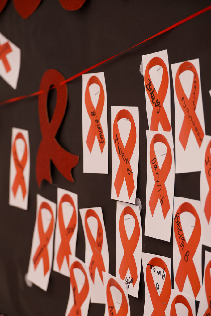 Close up of red ribbons pinned on the banner.