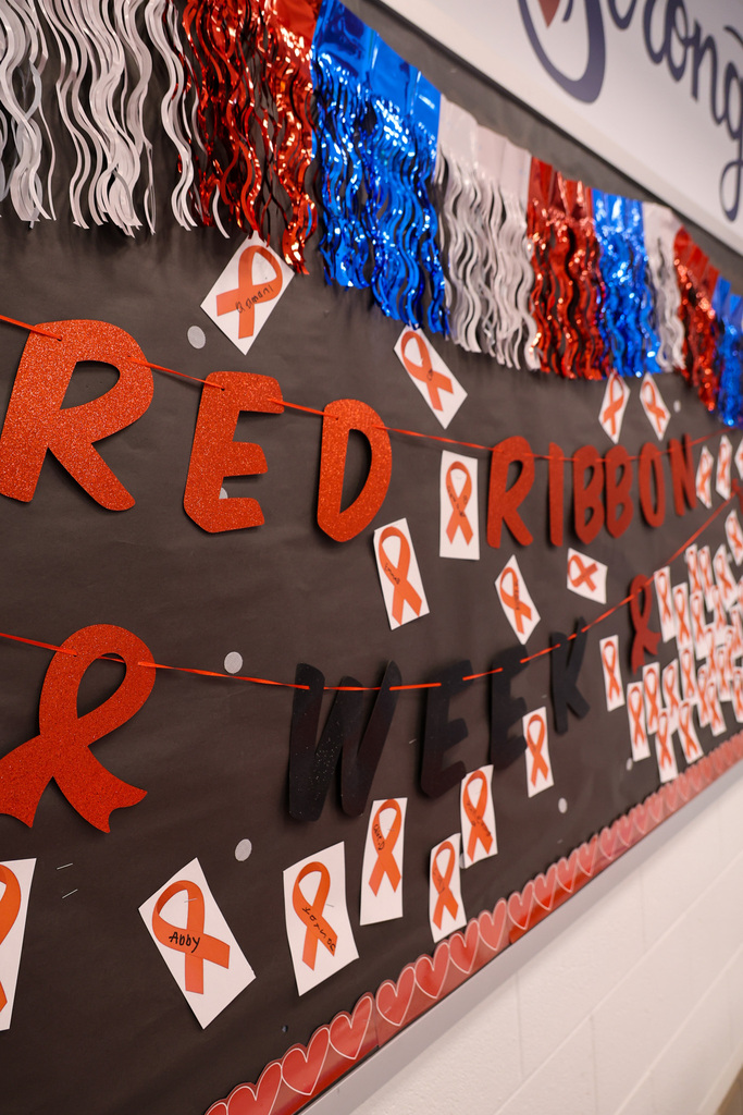 Photo of a banner at Peaks Mill Elementary that says "Red Ribbon Week" with a bunch of red ribbons pinned on the banner.