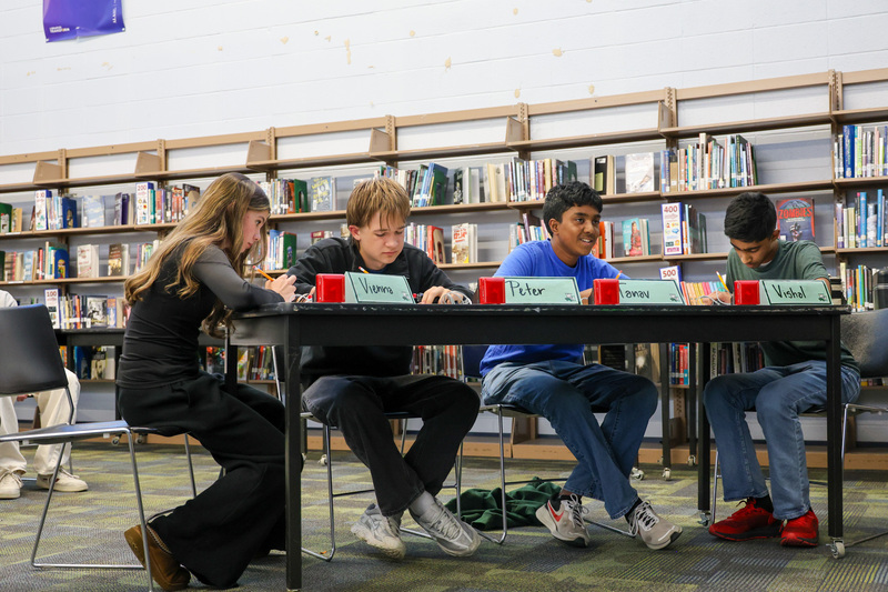 Four WHHS students sit at a table for the Quick Recall round with their buzzers.