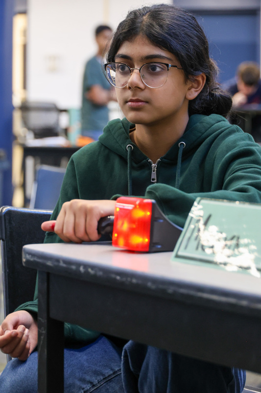 WHHS student looks forward with the buzzer lit up red.