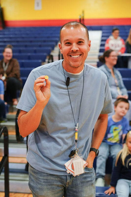 ELV staff member smiles with a coin he received for his class.