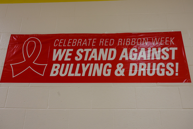 A banner that has a ribbon on the left side and text that reads "Celebrate Red Ribbon Week. We Stand Against Bullying & Drugs!" The banner is red.