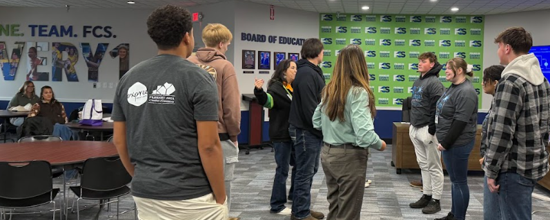 Students doing a grounding exercise with Tish in the board room.
