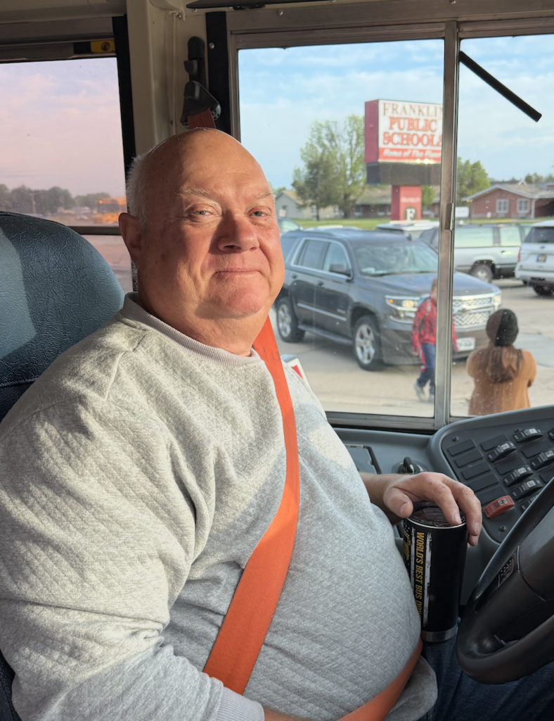 Gordon Bush, Franklin Public School bus driver in the drivers seat of his bus. 
