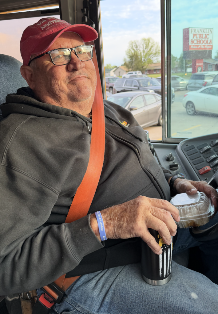 Al Smith, Franklin Public School bus driver in the drivers seat of his bus. 