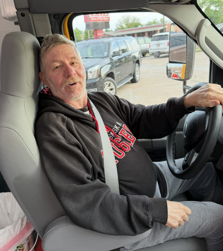 Calvin Crites, Franklin Public School bus driver in the drivers seat of his bus. 