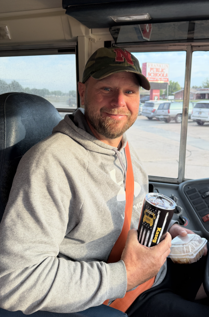 Kasey Loschen, Franklin Public School bus driver in the drivers seat of his bus. 