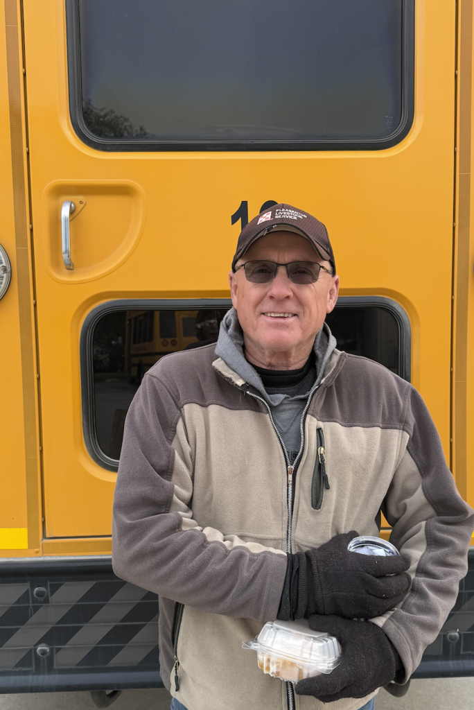 Stacey James, Franklin Public School bus driver standing in front of the school bus. 