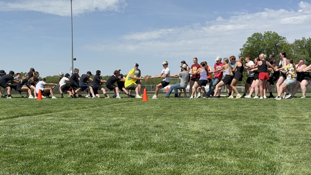 The 6th grade class and high school field day helpers playing tug of war. 