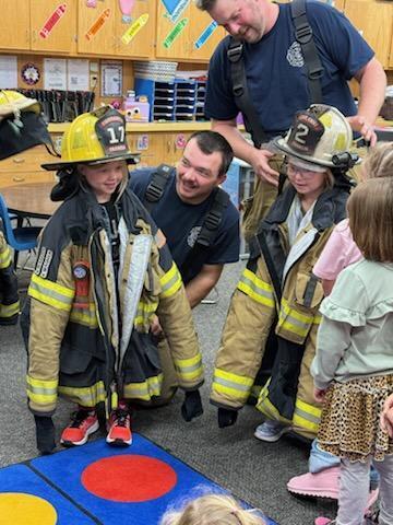 Kids try on the fireman's gear.