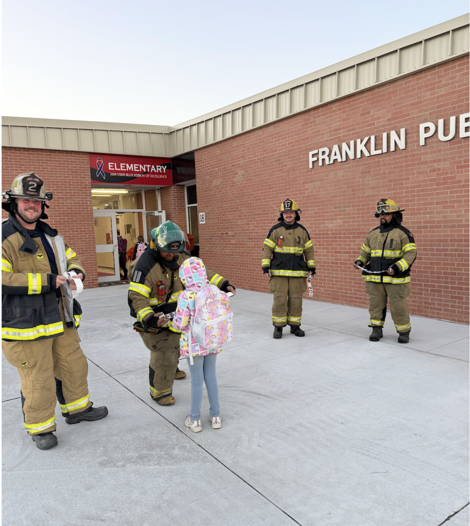 Franklin Fire Dept. Volunteers greeting kids as they enter the building.