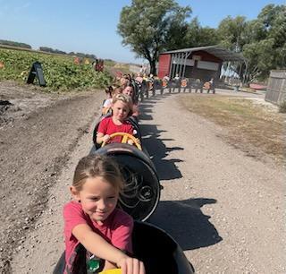 Students riding the train cart. 