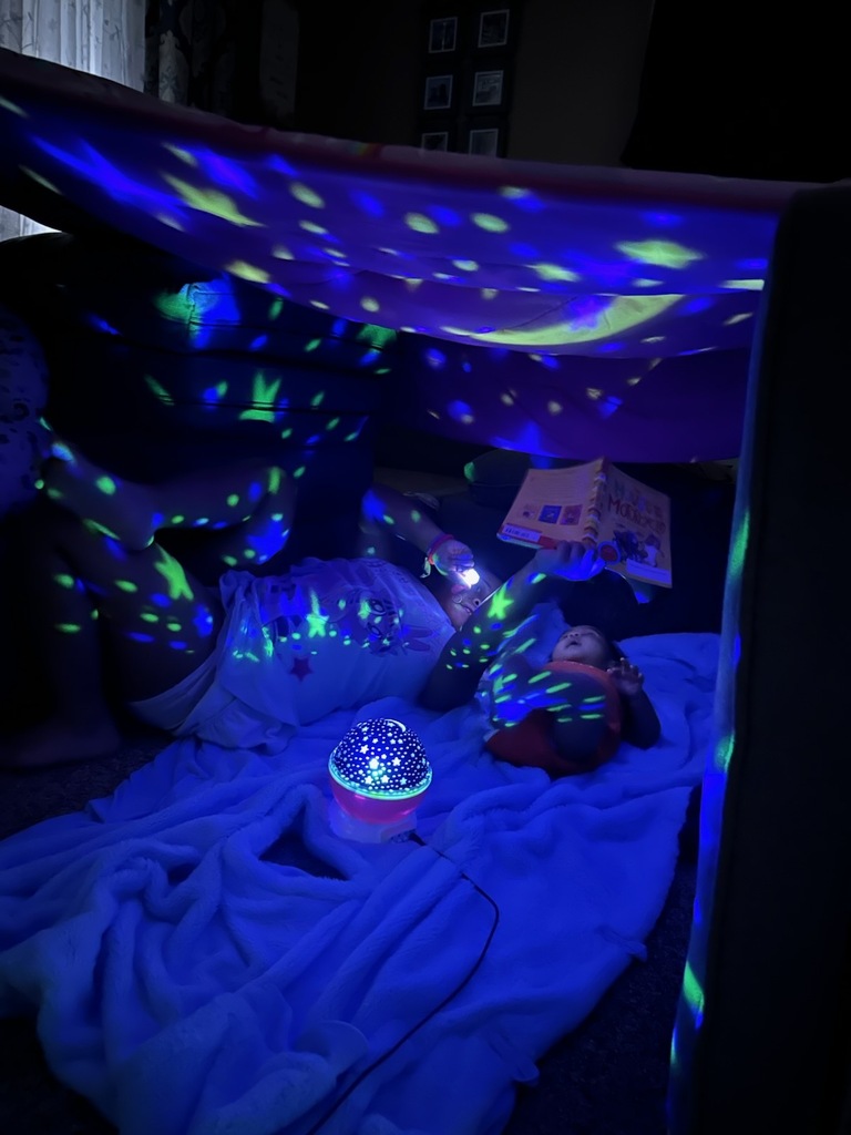 Reading with the lights on in their fort.
