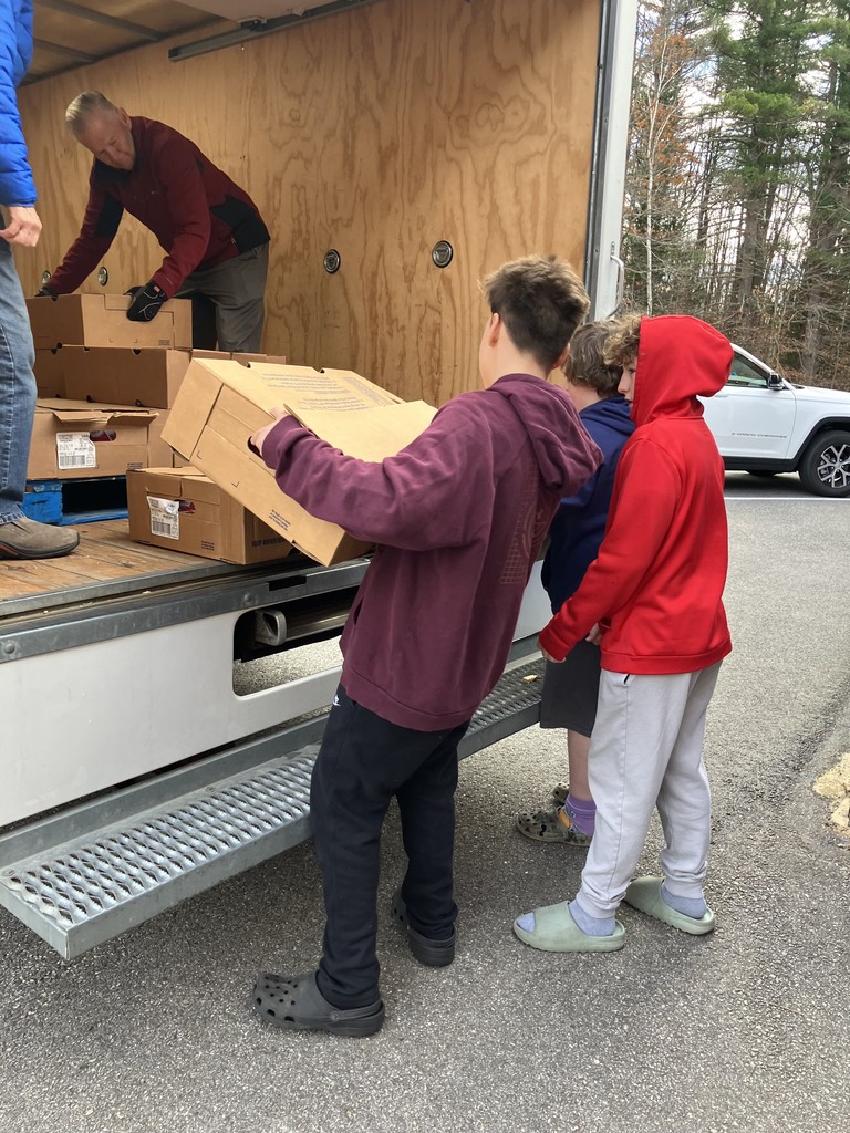 3 Middle School boys unloading turkeys from a box truck