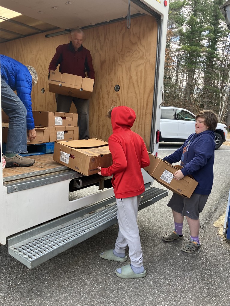 Two Middle School boys unloading a box truck of turkeys