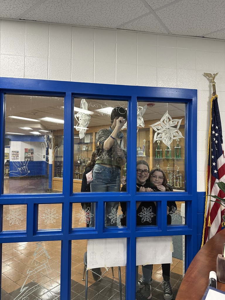 Middle School students drawing Christmas decorations on school windows