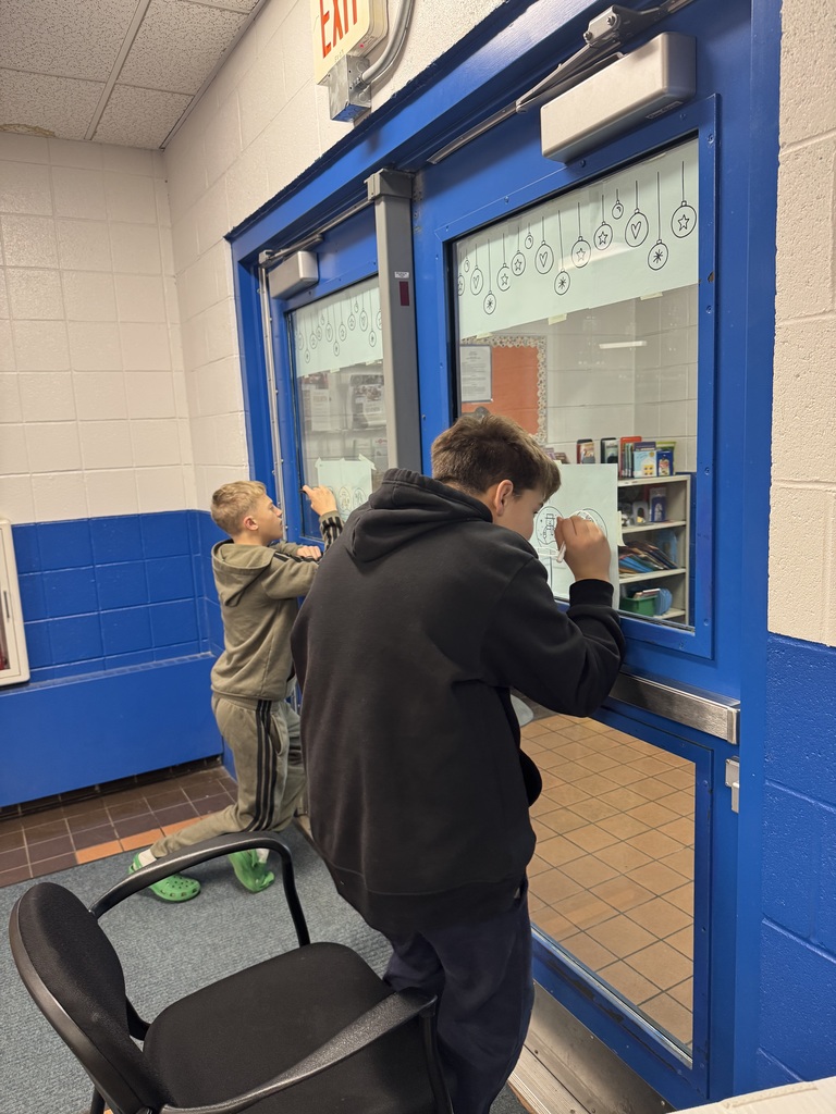 Middle School students drawing Christmas decorations on school windows