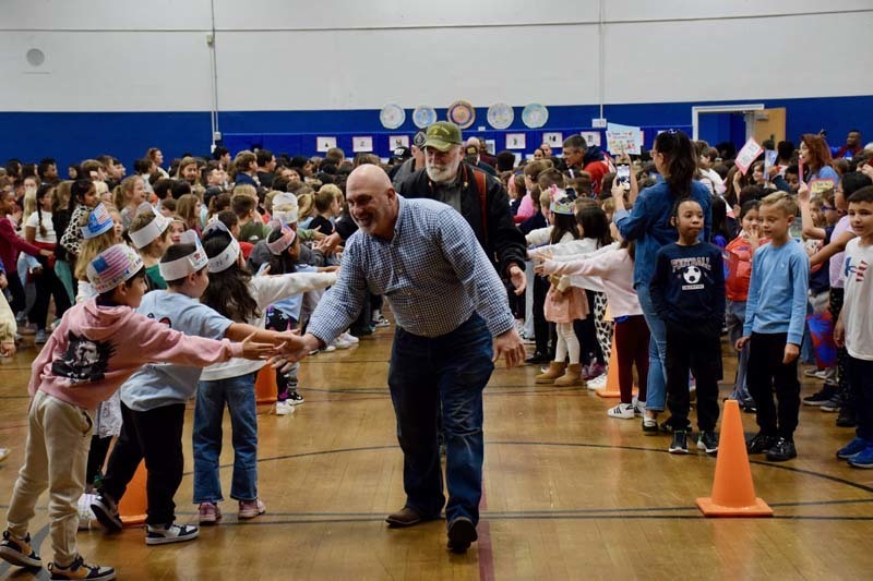 Veteran shaking hands with sutdents.