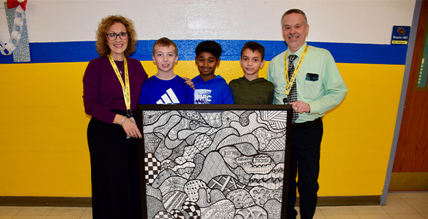 Students and teachers holding artwork.