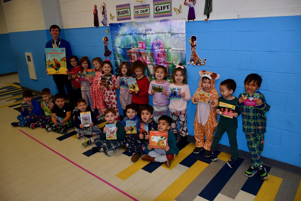 Students in pajamas standing with books