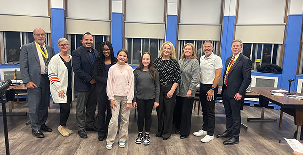 Students and BOE members smiling together.