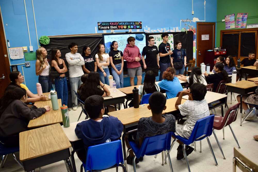 Students gving presentation to younger children.