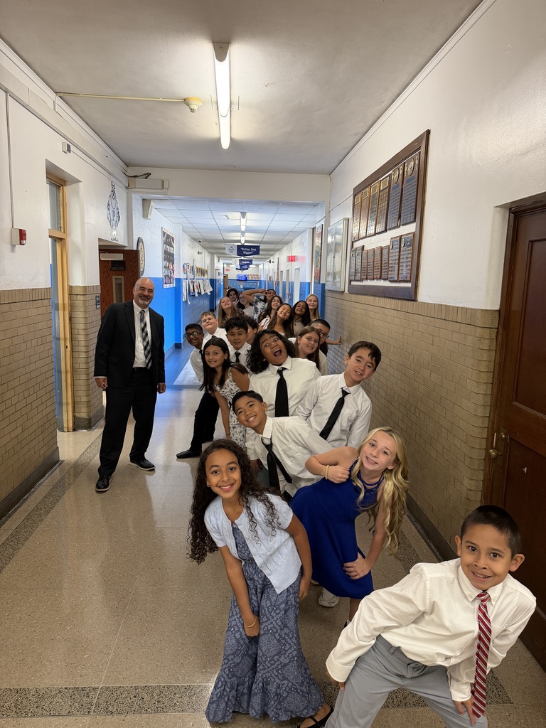 Students dressed in neat clothes in line and smiling, ready for picture day