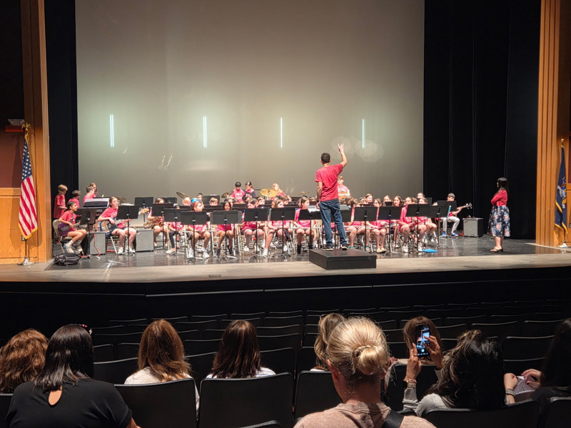 group of children in red shirts performing