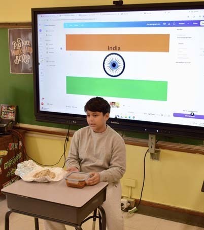 Student giving presentation at front of class.