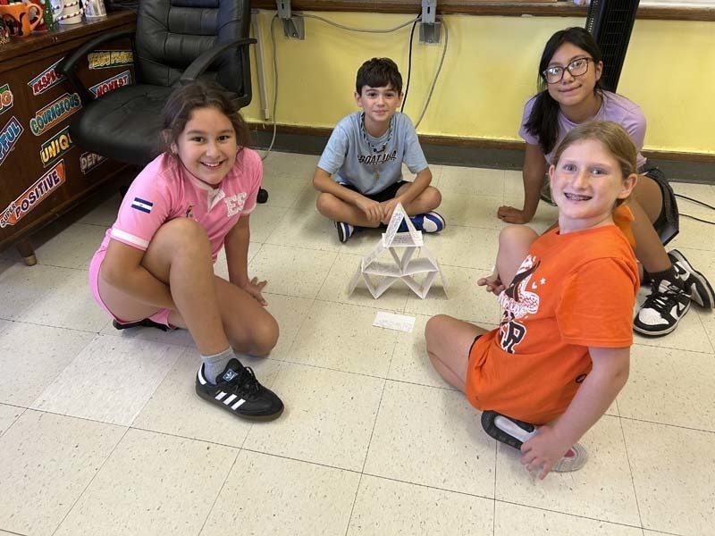 Students smiling at camera, sitting at table.
