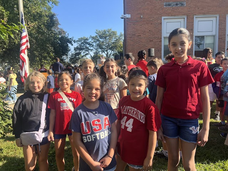people gather outside the school for a group shot