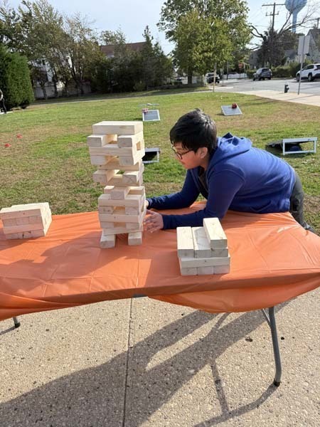 Students outside smiling at table.