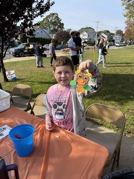 Students outside smiling at table.