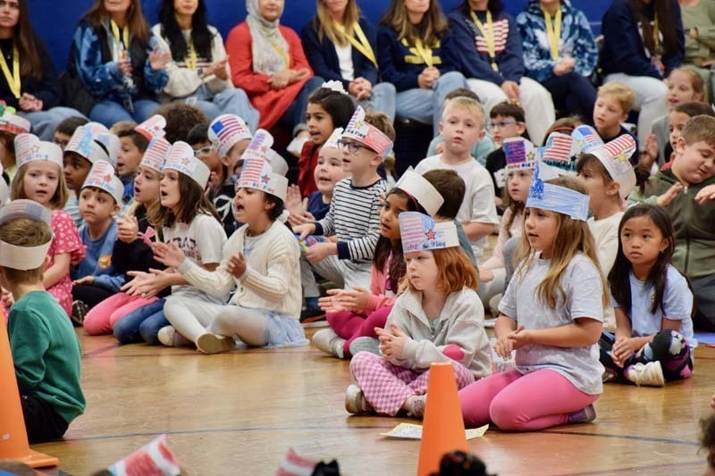 Students sitting on audituroium floor.