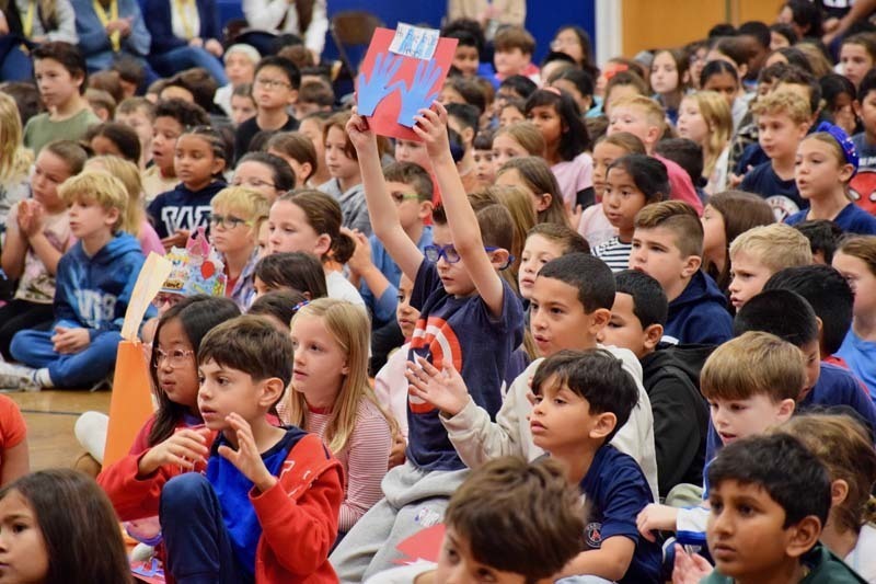 Students sitting on audituroium floor.