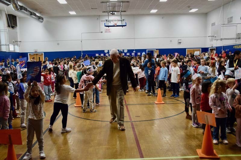 Veteran shaking hands with sutdents.