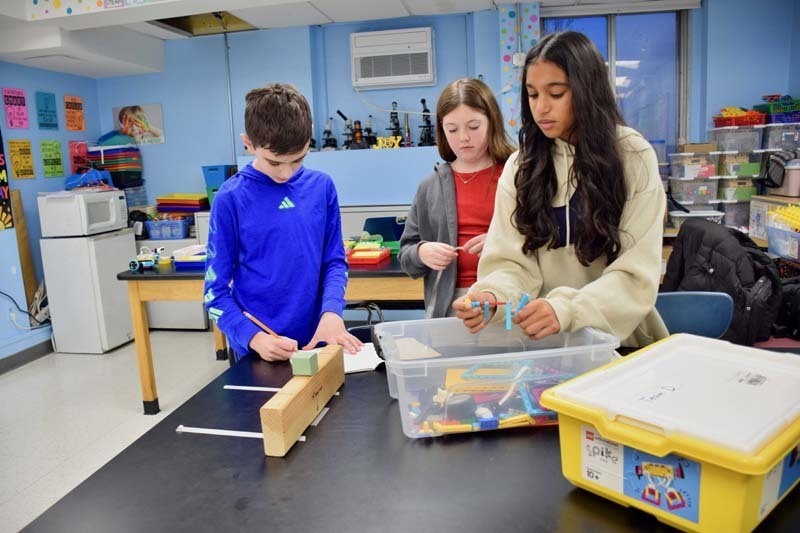 Teacher helping students with project.