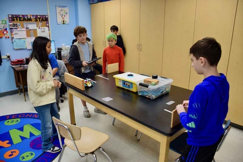 Teacher helping students with project.