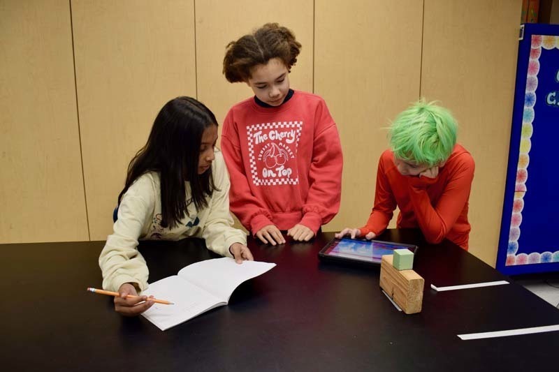 Teacher helping students with project.