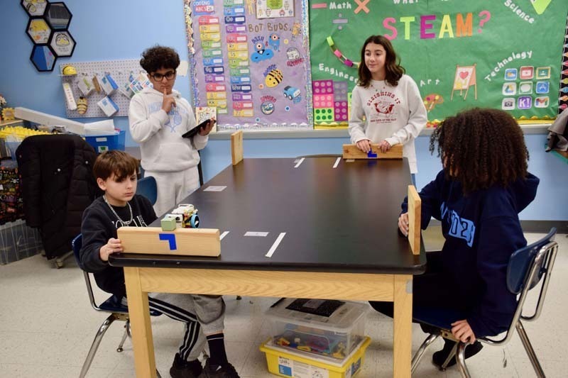 Teacher helping students with project.