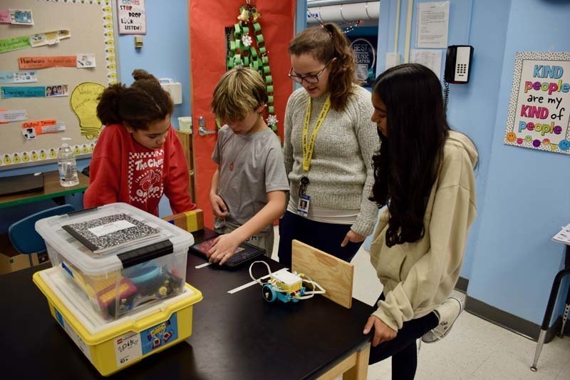 Teacher helping students with project.