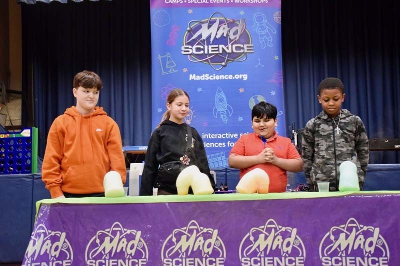 Students with "mad scientist" on stage.