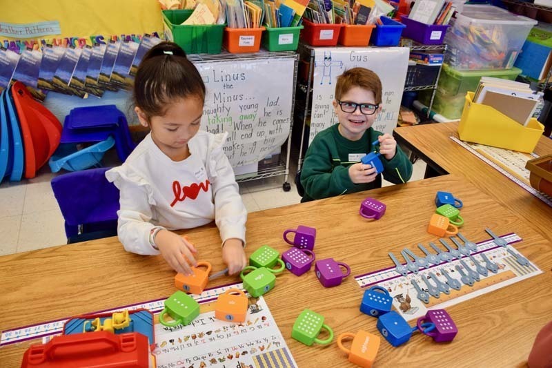 Students smiling while building with blocks.